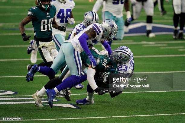 Darian Thompson of the Dallas Cowboys tackles Dallas Goedert of the Philadelphia Eagles during an NFL game on December 27, 2020 in Arlington, Texas.