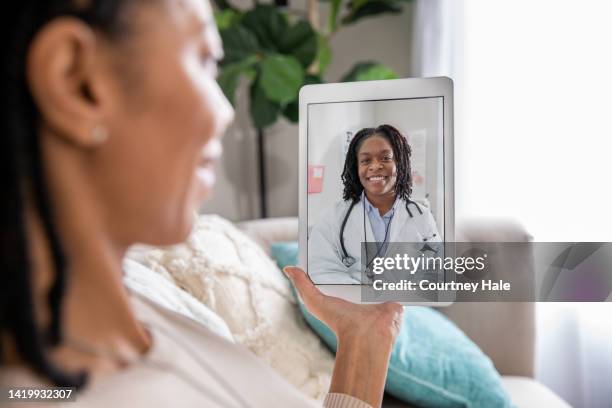 la donna matura discute di problemi di salute con il medico durante un appuntamento di telemedicina - evento virtuale foto e immagini stock