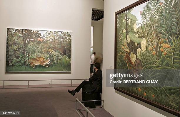 Guard looks at "Le lion ayant faim se jette sur l'antilope" of French artist Le Douanier-Rousseau 09 March 2006 at the Grand Palais museum in Paris...