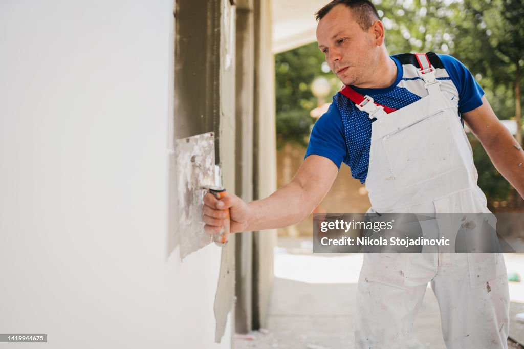The painter prepares the mesh for the facade
