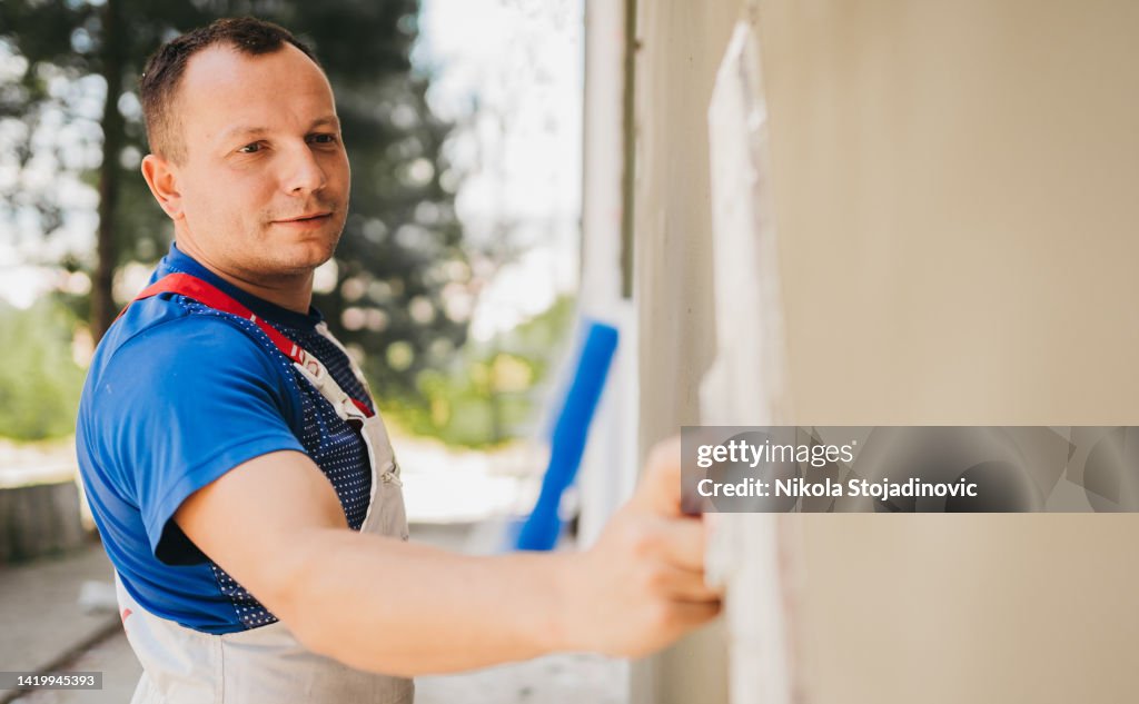 The painter prepares the mesh for the facade