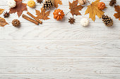Autumn concept. Top view photo of maple leaves pine cones small pumpkins walnut anise and cinnamon sticks on isolated white wooden table background with copyspace