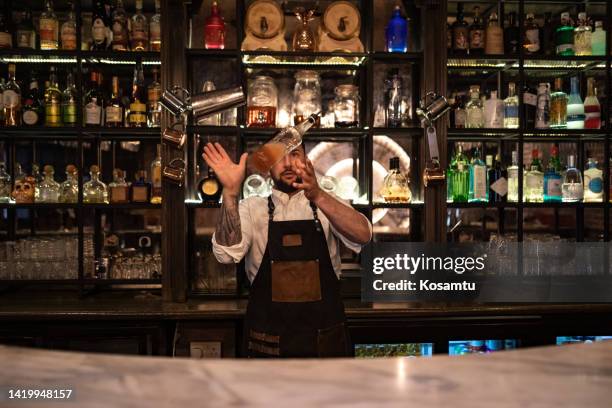 the handsome bartender mixes alcoholic drinks and makes cocktails - malta business stock pictures, royalty-free photos & images