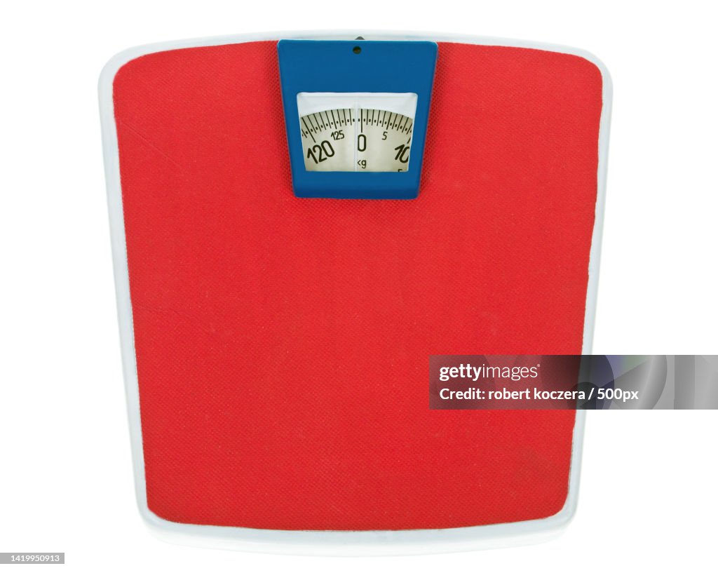 Close-up of red purse over white background