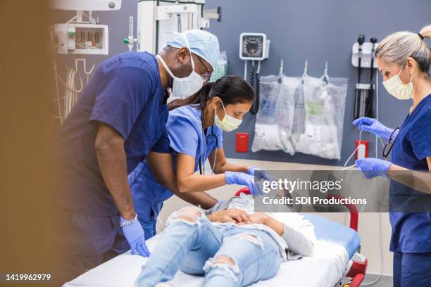 diverse emergency room team works on female patient - triage stock pictures, royalty-free photos & images