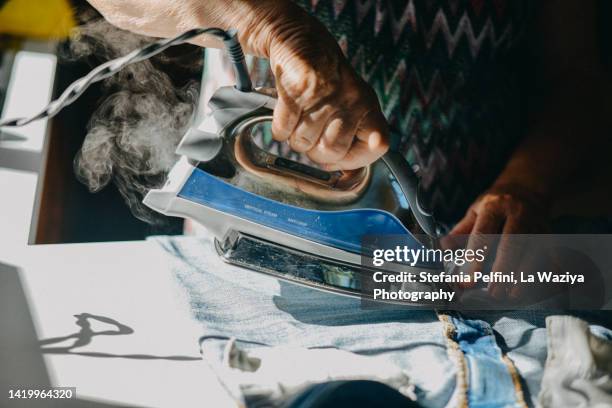 close up on ironing hand - ferro da stiro foto e immagini stock