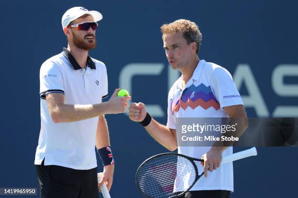 Jamie Murray of Great Britain and Bruno Soares of Brazil discuss against Hunter Reese of the United States and Max Schnur of the United States during...