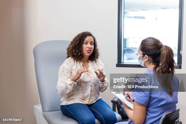 female patient talks to the doctor - mid adult women stock pictures, royalty-free photos & images