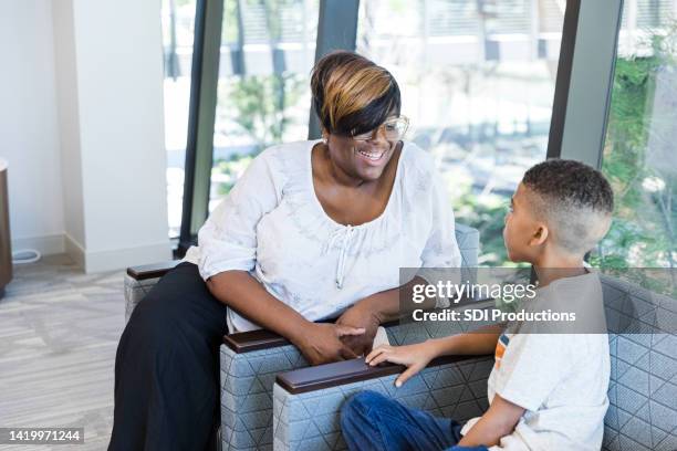 mother and son sit in the waiting room - child psychologist stock pictures, royalty-free photos & images