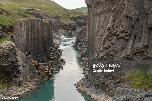personas incidentales en el cañón de studlagil, valle de jokuldalur - columna de basalto fotografías e imágenes de stock