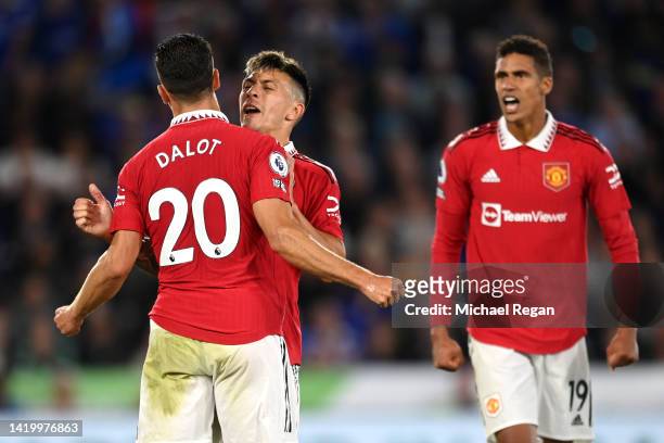 Diogo Dalot, Lisandro Martinez and Raphael Varane of Manchester United celebrate a defensive effort during the Premier League match between Leicester...