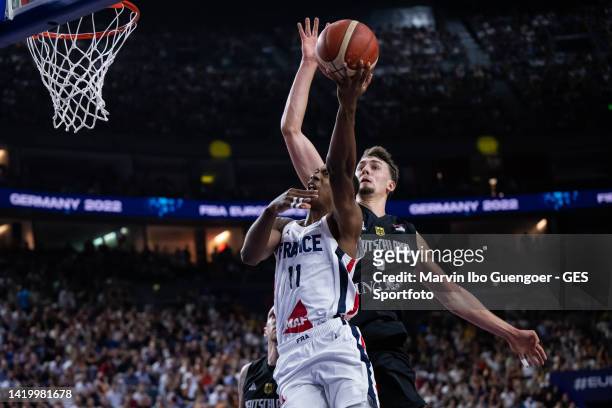 Theo Maledon of France is tackled by Franz Wagner of Germany during the FIBA EuroBasket 2022 group B match between France and Germany at Lanxess...