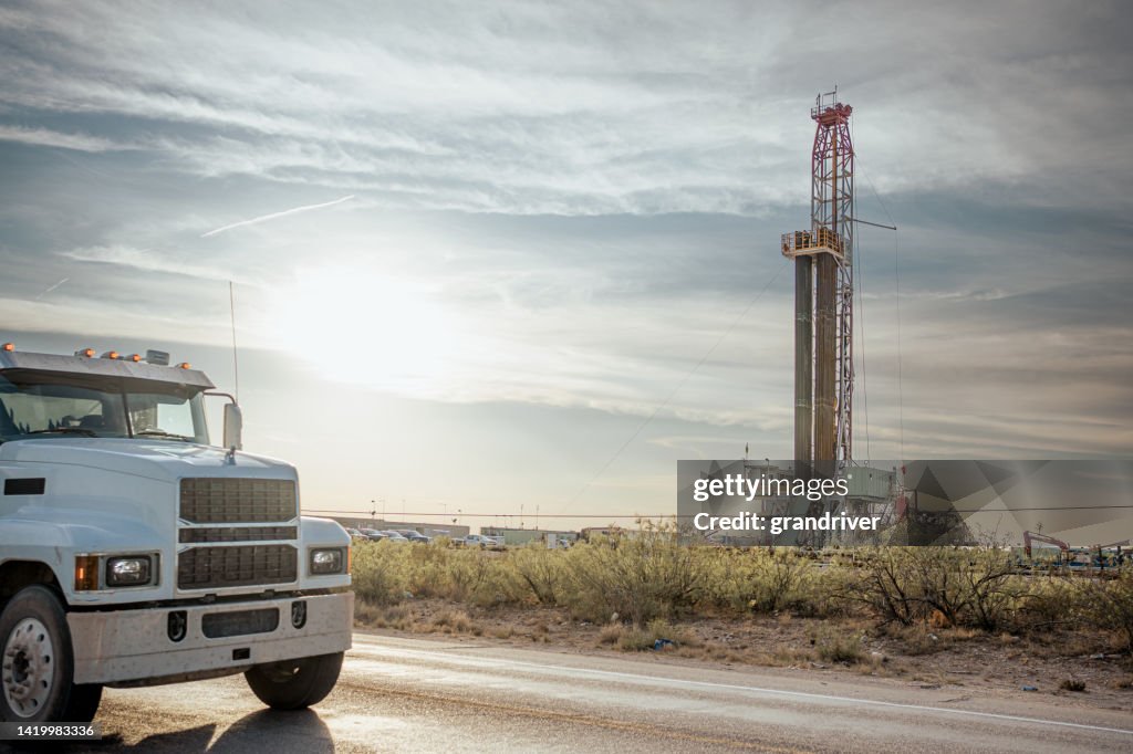 Plate-forme de forage de dragage créant un puits de gaz ou de pétrole silhouette au crépuscule sous un ciel spectaculaire au coucher du soleil