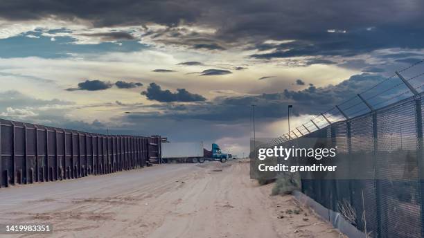 muro fronteiriço entre sunland park, novo méxico e puerto anapra chihuahua méxico perto da fronteira de santa teresa cruzando sob uma dramática paisagem de nuvens perto do crepúsculo - fronteira - fotografias e filmes do acervo