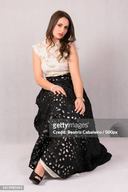 portrait of beautiful young woman in dress sitting against white background,pereiras,spain - retrato formal photos et images de collection