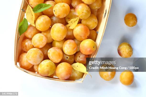 high angle view of sweet orange fruits in container on table - mirabellen stockfoto's en -beelden