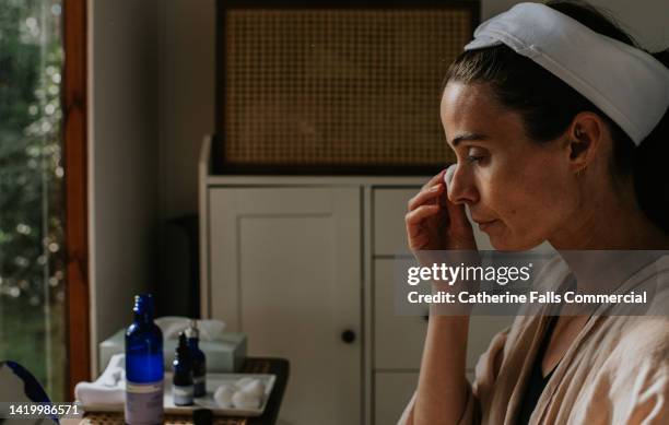 a woman removes her eye make-up using a cotton ball - woman applying cotton ball bildbanksfoton och bilder