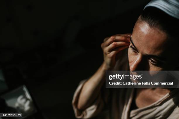 close-up, top down image of a woman cleansing her skin with a cotton ball - woman applying cotton ball stock pictures, royalty-free photos & images