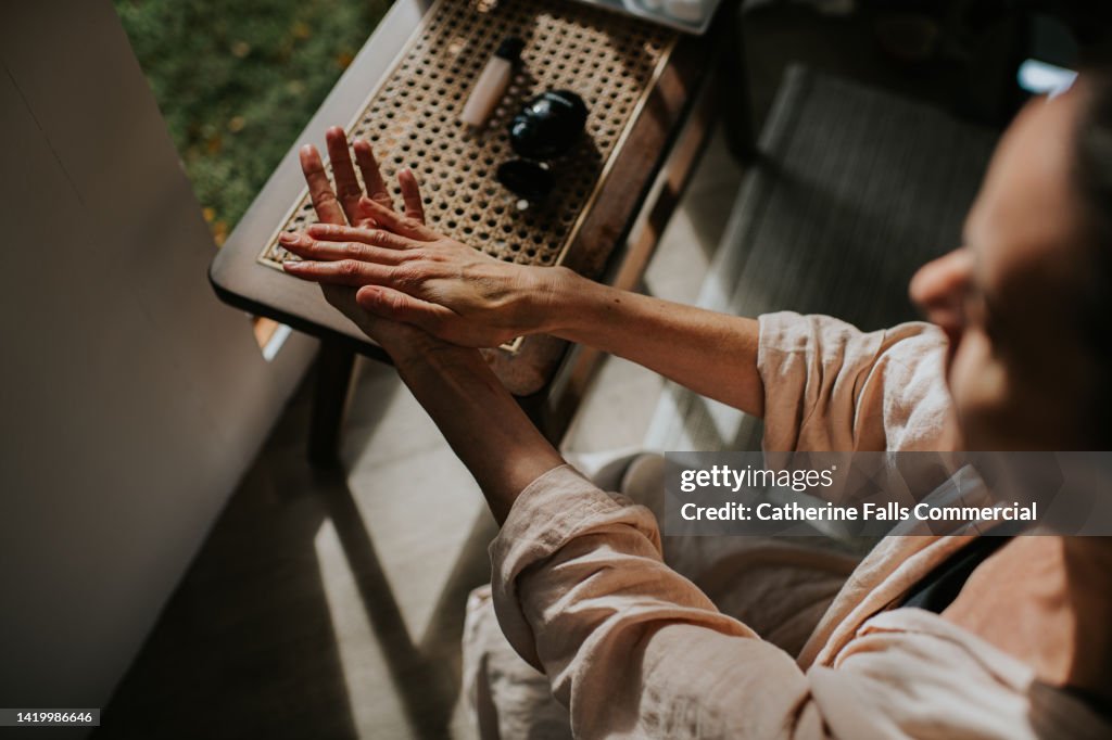 A woman moisturises her hands