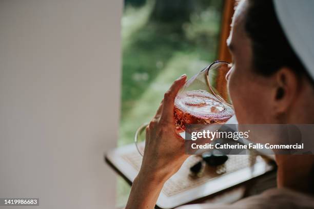 a woman indulges in a glass of champagne during a spa session. - pampers stockfoto's en -beelden