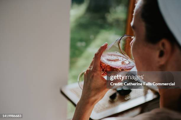 a woman indulges in a glass of champagne during a spa session. - bucks fizz cocktail stock pictures, royalty-free photos & images