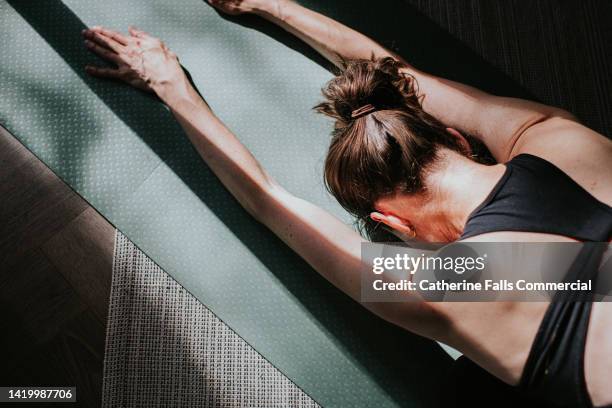 close-up image of a woman in child's pose position - older woman bending over stock pictures, royalty-free photos & images