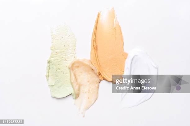 set of textured cosmetic smears smudged on white background. moisturizing cream, exfoliating scrubs and cleansing facial mask. everything for your skincare and anti aging procedures. flat lay style - scrubs stock pictures, royalty-free photos & images