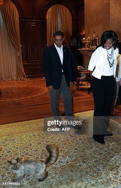 Picture taken July 6 shows US President Barack Obama and his wife Michelle looking at Dorofey, a Neva Masquerade cat of Russia's President Dmitry...