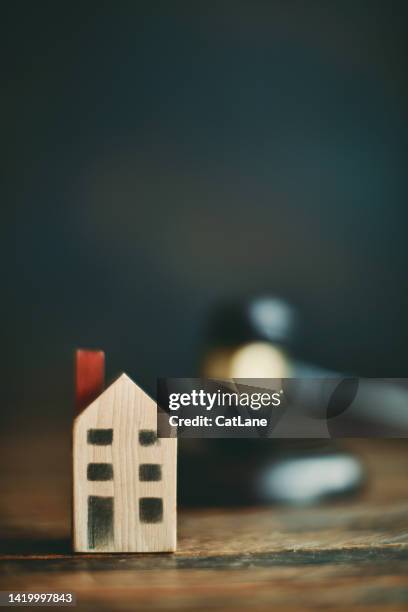 small wooden house with gavel in background. auction and legal theme - house auction imagens e fotografias de stock