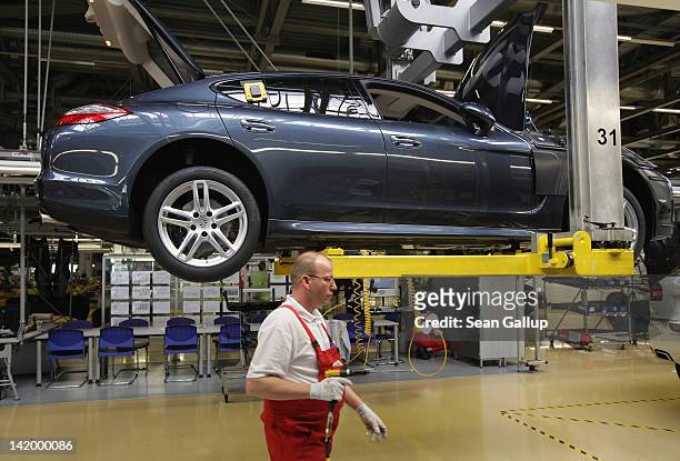 Workers assemble Porsche Cayenne and Panamera cars at an assembly line at the Porsche factory on March 28, 2012 in Leipzig, Germany. The Cayenne and...