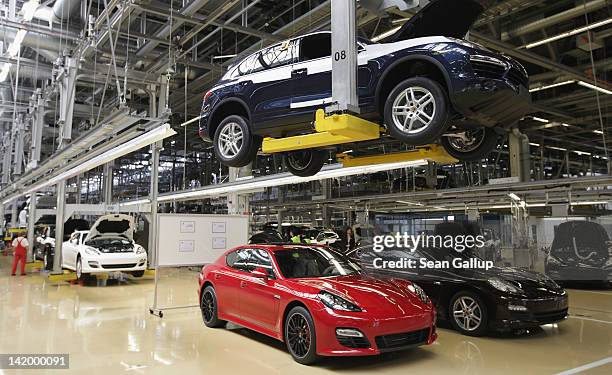 Workers assemble Porsche Cayenne and Panamera cars at an assembly line at the Porsche factory on March 28, 2012 in Leipzig, Germany. The Cayenne and...