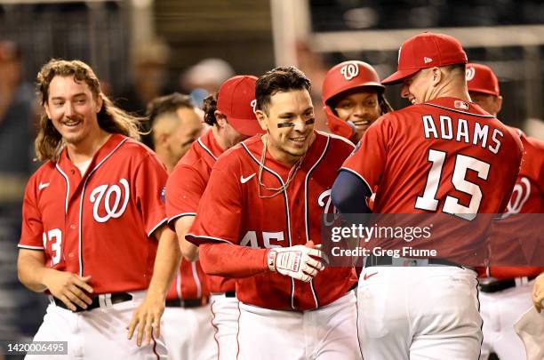 Joey Meneses of the Washington Nationals celebrates with teammates after hitting the game winning three-run home run in the tenth inning against the...