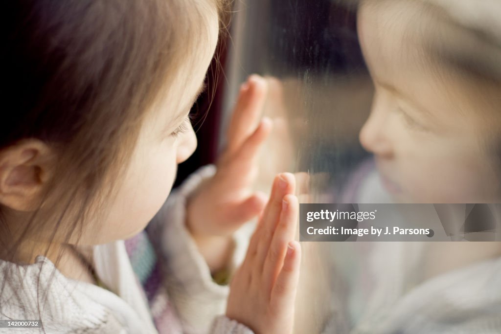 Girl looking through window