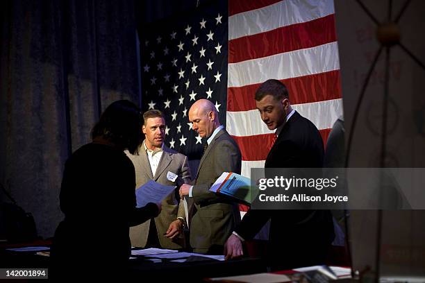 People meet potential employers during a job fair for military veterans and spouses aboard the U.S.S. Intrepid Sea, Air, and Space Museum March 28,...