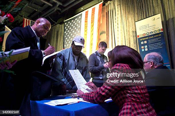 People meet potential employers during a job fair for military veterans and spouses aboard the U.S.S. Intrepid Sea, Air, and Space Museum March 28,...