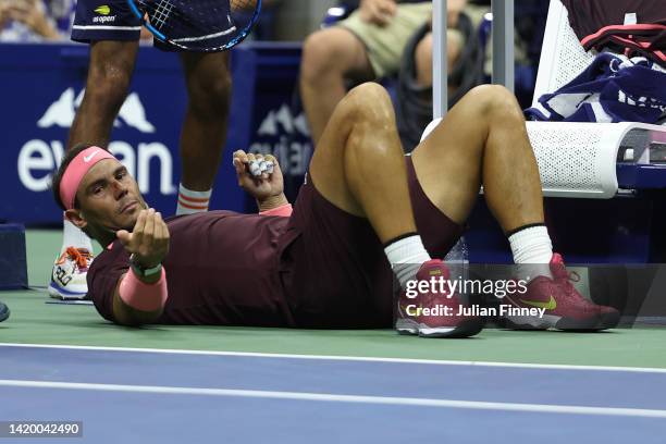 Rafael Nadal of Spain lies on the ground after accidentally hitting himself in the head with his racket against Fabio Fognini of Italy during their...