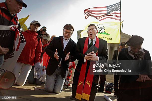 Rev. Rob Schneck and Rev. Patrick Mahoney lead people in prayer outside the U.S. Supreme Court on the third day of oral arguements over the...