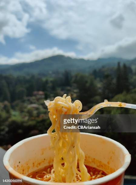 eating noodles with hills view - cup noodles stock-fotos und bilder