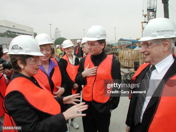 Wearing hardhats and reflective vests LA Philharmonic CEO Deborah Borda and Architect Frank Gehry converse while Music Director Esa-Pekka Salonen and...