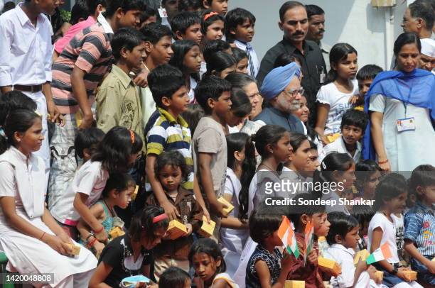 Congress President Sonia Gandhi with Prime Minister Manmohan Singh sit with underprivileged school children for a group photo during Independence Day...