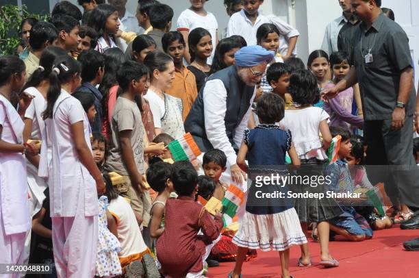 Congress President Sonia Gandhi with Prime Minister Manmohan Singh sit with underprivileged school children for a group photo during Independence Day...