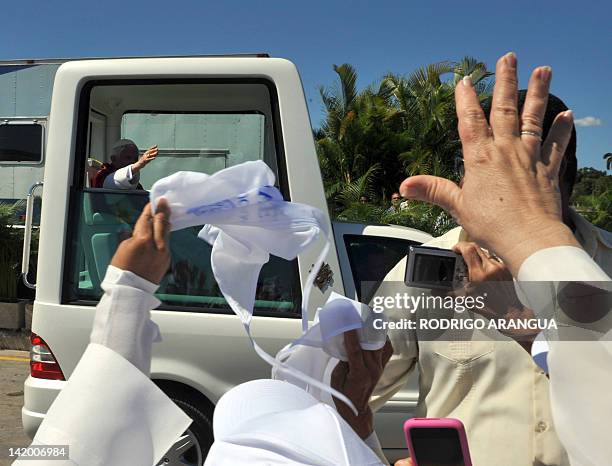 Pope Benedict XVI greets believers from the popemobile after celebrating a mass at Revolution Square in Havana, on March 28, 2012. Benedict XVI was...