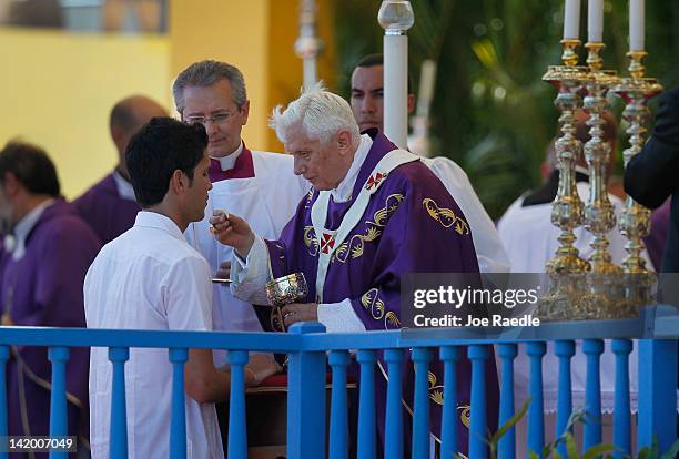 Pope Benedict XVI gives communion during his mass at Havana's Revolution Square on the last day of his three day visit on March 28, 2012 in Havana,...