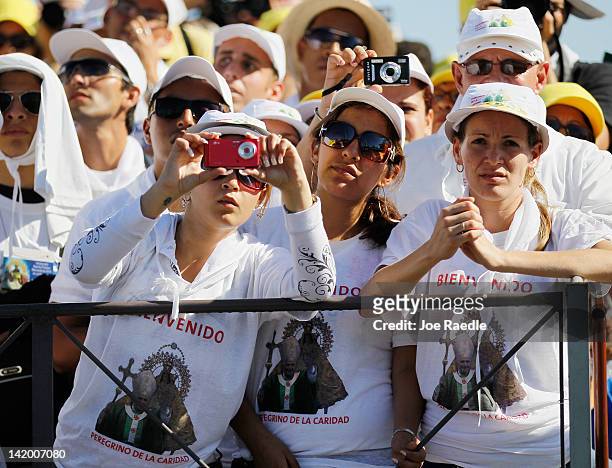 People watch as Pope Benedict XVI conducts his mass at Havana's Revolution Square on the last day of his three day visit on March 28, 2012 in Havana,...