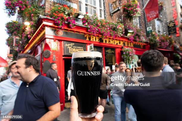 Pint of Guinness beer outside the The Temple Bar on August 19, 2022 in Dublin, Ireland. Dublin is the capital of the Republic of Ireland, is located...