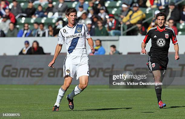 Andrew Boyens of the Los Angeles Galaxy passes back to goalkeeper Josh Saunders as Chris Pontius of D.C. United pursues the play during the MLS match...