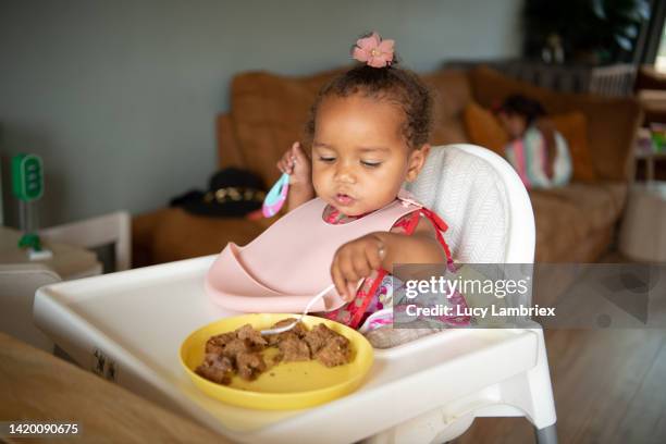 cute one-year-old eating a peanut butter sandwich - toddler eating sandwich stock-fotos und bilder