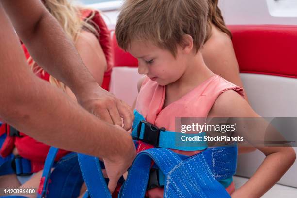 close up father fastening son life vest - fastening stock pictures, royalty-free photos & images