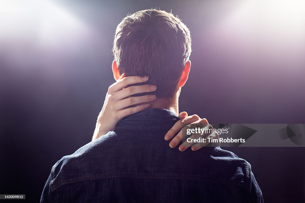 Man with womans hands touching his head.