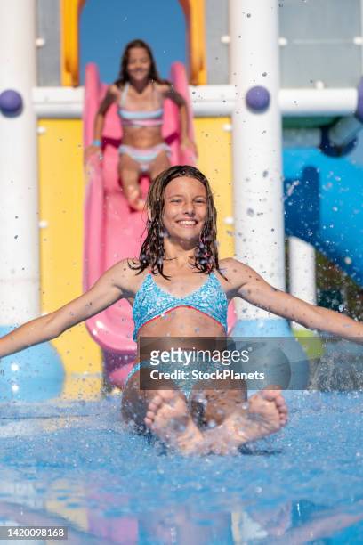 fille gaie ayant l’amusement glissant dans le parc d’eau - ado en maillot de bain photos et images de collection